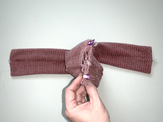 Rassembler le bandeau en noeud puis fermer la couture